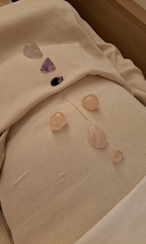 Piedras alineadas sobre el cuerpo en una sesión de sanación energética